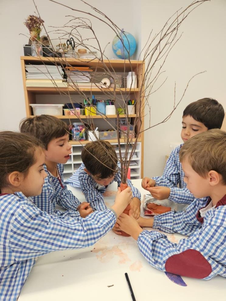 Crianças à volta de uma mesa a construir a árvore das rimas